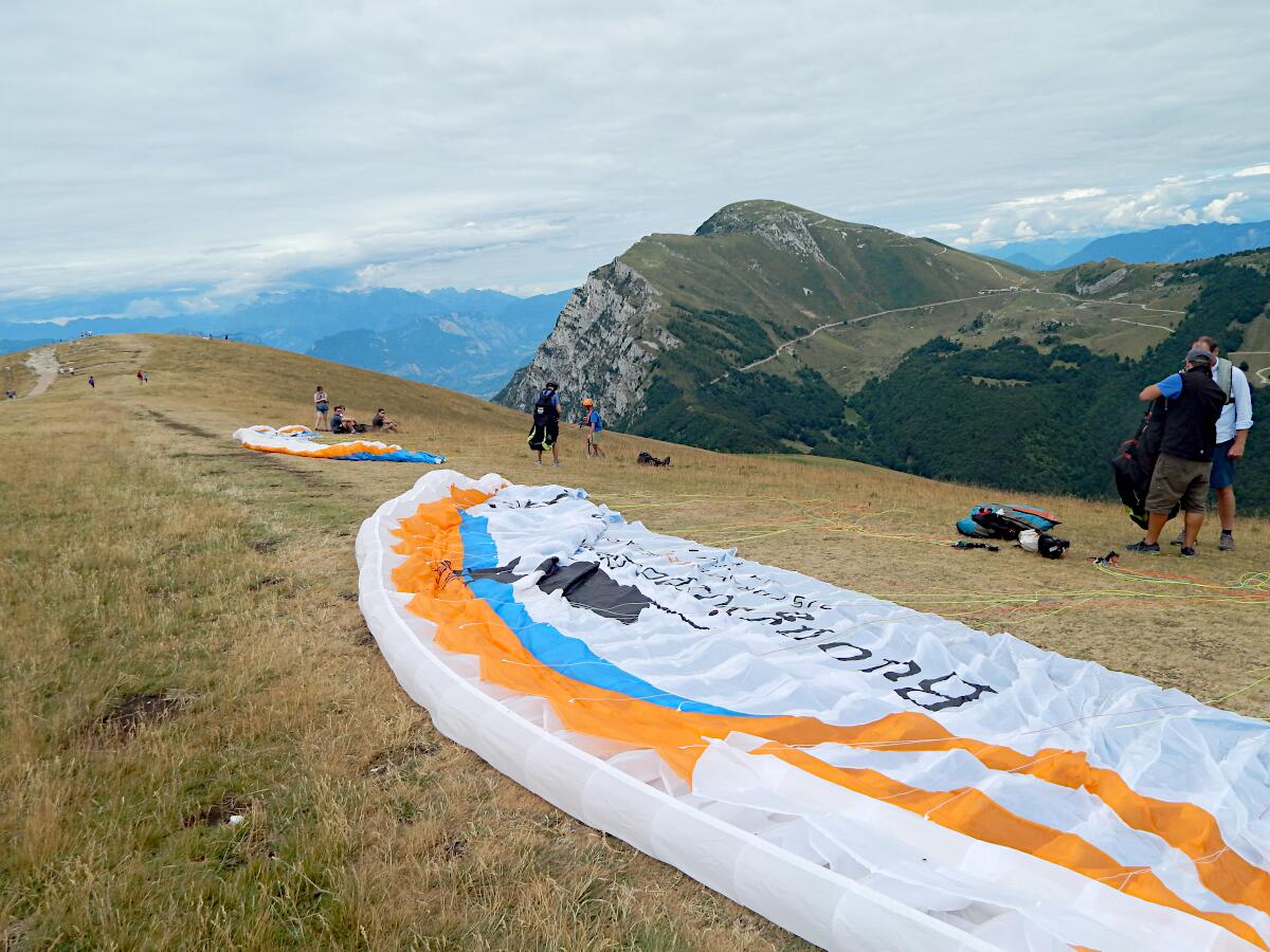Gleitschirmstart am Monte Baldo - im Hintergrund Monte Altissimo di Nago