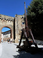 San Quirico d'Orcia - Stadttor an der Piazza della Libert (im Vordergrund Nachbau einer mittelalterlichen Blide)